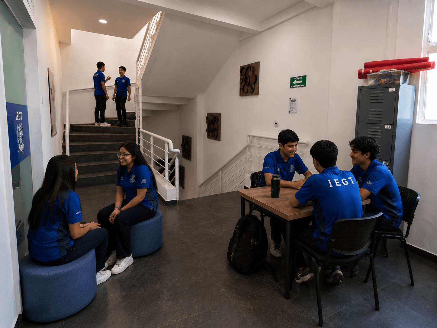 Estudiantes conversan en un área de convivencia junto a las aulas